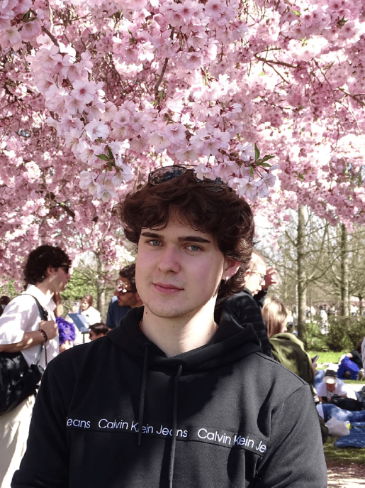 Foto profilo, alle spalle ci sono dei cigliegi in fiore